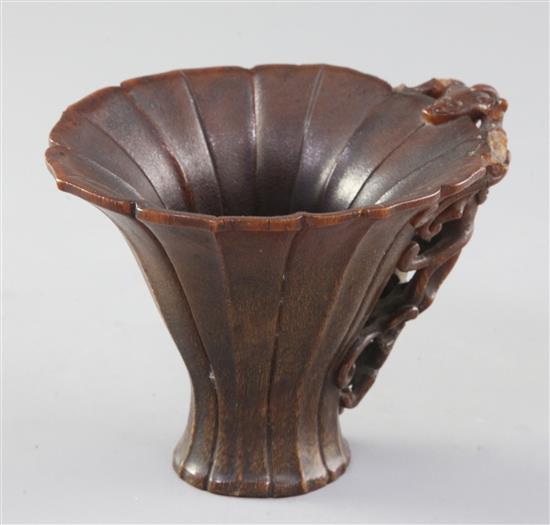 A Chinese rhinoceros horn libation cup, 17th century, width 9.7cm height 9.5cm length 12.6cm, losses to handle and small rim chips
